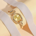 Elegant gold bangle watch with horsebit style case and Roman numeral dial indices - Gold Case Gold Dial
