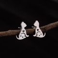 Detail of silver cat stud earrings with heart cutouts on a rustic wooden branch - Steel