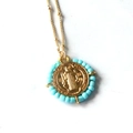 Dettaglio del ciondolo medaglia San Benedetto dorato con perline azzurre e catenina - Celeste