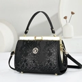 Elegant black snake pattern handbag with gold hardware and circular logo on white surface - Snake Pattern Black