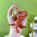 Red cartoon T-Rex keychain with golden bell and ring, featuring movable head part - Red Brown