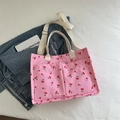 Pink tote bag with cherry print featuring front pockets and adjustable shoulder strap - Pink