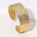 Macro detail of golden irregular hammered texture on stainless steel wide open cuff bangle - Gold (SZ055)