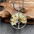 Detail of life tree pendant with yellow gemstones on a textured wooden stand - Citrine