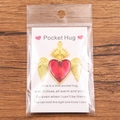 Golden winged heart Pocket Hug charm with red enamel finish on a gift card display - Gold Large Wings Red Heart