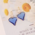 Dettaglio di orecchini a cuore blu profondo con gancio a fiore dorato e sfondo floreale - Blu Reale