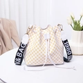 Borsa a secchiello in PU bianca a pois gialli con ampia tracolla logata su tavolo bianco - Bianco