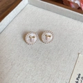 Primer plano de arete de perla floral rosa con lazo dorado en bandeja de joyería beige - Aro de Perla con Lazo Blanco (5# Pin de Plata - Oro Blanco)