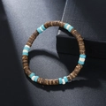 Close-up of handmade coconut shell and turquoise beaded bracelet on a dark textured surface - ZJ11932-Brown and Blue Multi-Material Bracelet