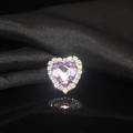 Macro shot of heart-shaped purple crystal gem with silver claw setting on black silk - Light Purple