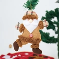 Detailed view of burlap Santa hanging ornament with plush details and wood button on pine - Santa Claus