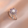 Silberner Blumenring mit lila Edelsteinen und weißer Perle auf rosa Seidenstoff - Lila Silber Gänseblümchen Ring