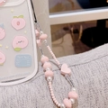 Macro shot of pink heart beads and pearls on phone strap with cute peach case - Pink Heart Beaded Lanyard