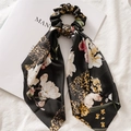 Vista dettagliata di elastico in raso con stampa leopardata e floreale su sfondo in tessuto - Floreale Satinato Nero