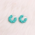 Minimalist twisted C-shape hoop earrings in vibrant teal finish on white faux fur - Small Lake Blue Twisted