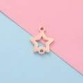 Vista macro de conector de estrella oro rosa para joyas DIY sobre fondo bicolor - Oro Rosa