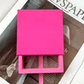 Caja de regalo tipo cajón en color rosa con asa de cinta sobre una revista de moda - Rosa Fuerte/Interior 9x9x2cm/Sin Impresión
