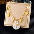 Detailopname van 18K vergulde ketting met oceaanhangers zoals zeesterren en schelpen - Dolfijn Wulk Multi-Hanger Stijl (N3462)