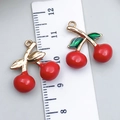 DIY cherry pendants in red enamel with gold stem beside a ruler for size reference - Large Drip Oil Cherry (23407)