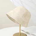 Minimalist beige suede bucket hat for women on a gold stand with elegant matte finish - Beige