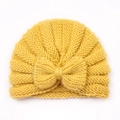 Detail of yellow knitted baby turban hat with a large decorative bow and ribbed texture - Yellow