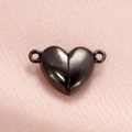 Primer plano de dos cierres magnéticos negros en forma de corazón con anillos para joyería - Negro