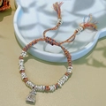 Detail of woven multi-color rope bracelet with silver metal charms and tassel - Colored Rope Silver Spacers Bracelet: Money Bag
