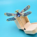 Spilla a libellula dorata con grande pietra blu su portagioie color avorio - Blu