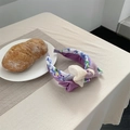 Detalle de diadema ancha de flores moradas con lazo de doble capa en mesa beige - Púrpura Romántico