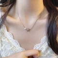 Silver bow necklace with white pearl and starfish charm worn by a model on lace top - Starfish Shape Simple Style (X1475) / Silver/Pearl Decor