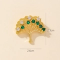 Detail shot of a 2.3x2.6cm gold tree brooch with green and white round zircon stones - 0370-1 Gold Tree Brooch