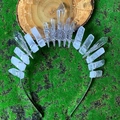Macro shot of silver crystal headband with moon symbol on green moss background - White + Large Triple Moon