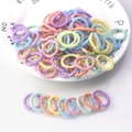 Dettaglio di elastici per capelli colorati senza cuciture impilati su un piatto decorativo in ceramica - Linea Filettata Colore Gelato 100 Pezzi