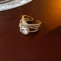 Vista detallada del anillo dorado multicapa con circón ovalado y engaste micro-pave fino - Dorado