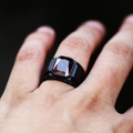 Primer plano de anillo negro para hombre con gran piedra roja rectangular en el dedo - Talla EE. UU. 7 / Negro con piedra preciosa roja