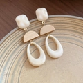 Asymmetric beige resin earrings with golden metal accents on a ceramic plate - Beige/Gold Hollow Teardrop
