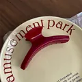 Close-up of a burgundy acetate hair claw with golden Barrette La France text engraving - Hanger Style