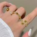 Vintage gold ring set with tiger eye stones and crystals on white manicured hands - Gold Metal Vintage Layered Ring Set