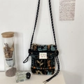 Close-up of plush crossbody bag with colorful abstract pattern on a white wall decor - Maple Leaf