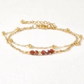Macro detail of double-layer gold chain with brown semi-precious beads and lobster clasp - Reddish Brown/Goldstone