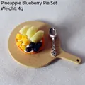 Macro shot of dollhouse miniature blueberry pineapple pie with wooden tray and silver spoon - Pineapple Blueberry Pie