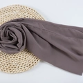 Deep brown-purple chiffon hijab wrap with fine texture on natural woven mat - 121