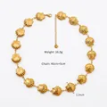 Détail d'un collier coquillage doré avec une chaîne réglable de 40+5cm et un fermoir - Collier Doré 16mm
