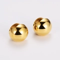 Dettaglio di orecchini a sfera dorati lucidi con una superficie a specchio brillante - Oro