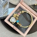 Close-up of gold beaded bracelet watch with floral charms and crystals in a gift box - Gold Blue Pink Bracelet With Box