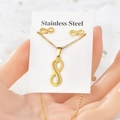 Vue macro de l'ensemble collier et boucles d'oreilles symbole infini doré en acier - Infini