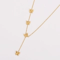 Detalle macro de los colgantes de mariposa dorados y la cadena de borlas del collar - Dorado