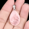 Pink rose quartz teardrop pendant with silver metal bail held in hand on black background - Rose Quartz (1pc)