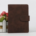 Funda de pasaporte en cuero marrón con relieve de avión y cierre de presión - Café