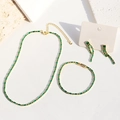 Gold plated emerald zircon jewelry set with necklace earrings and bracelet on stone props - Three-Piece Set